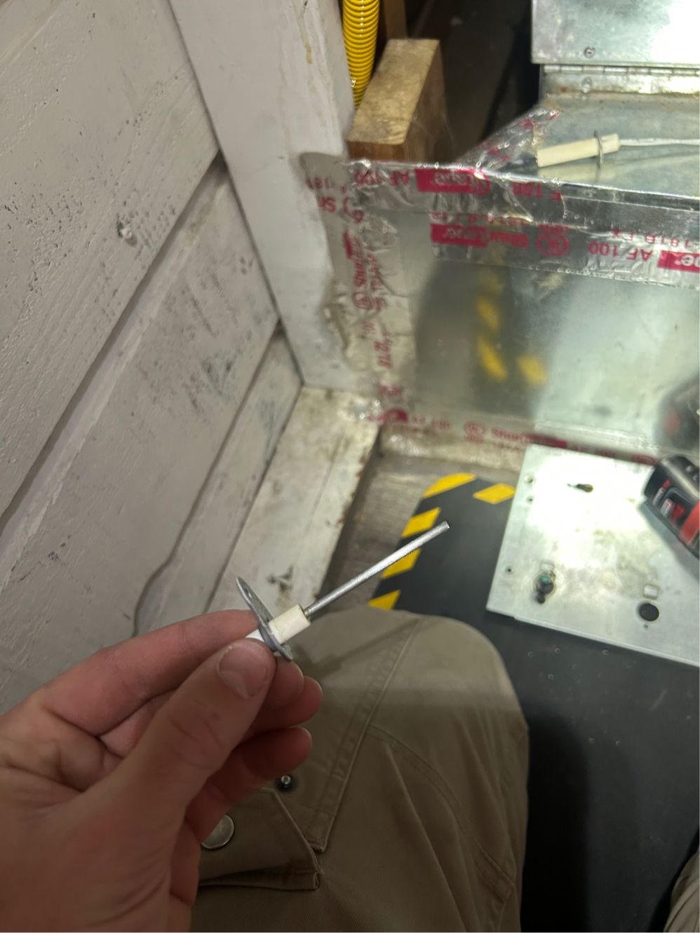 A furnace flame sensor removed for cleaning during a repair