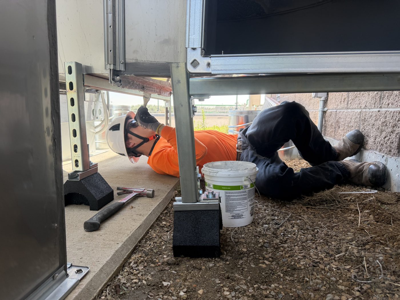Longview technician installing and sealing HVAC equipment on a job site